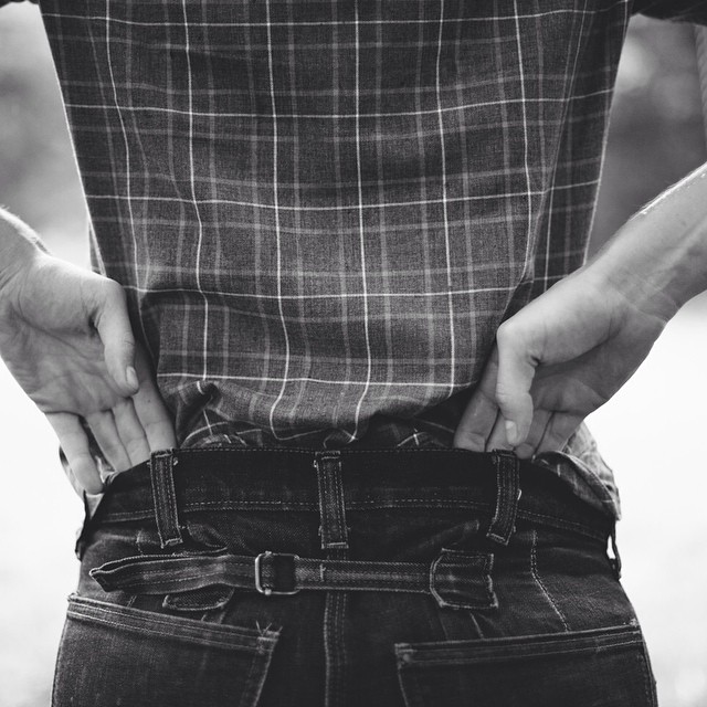 black and white pograph of someone holding their pants back