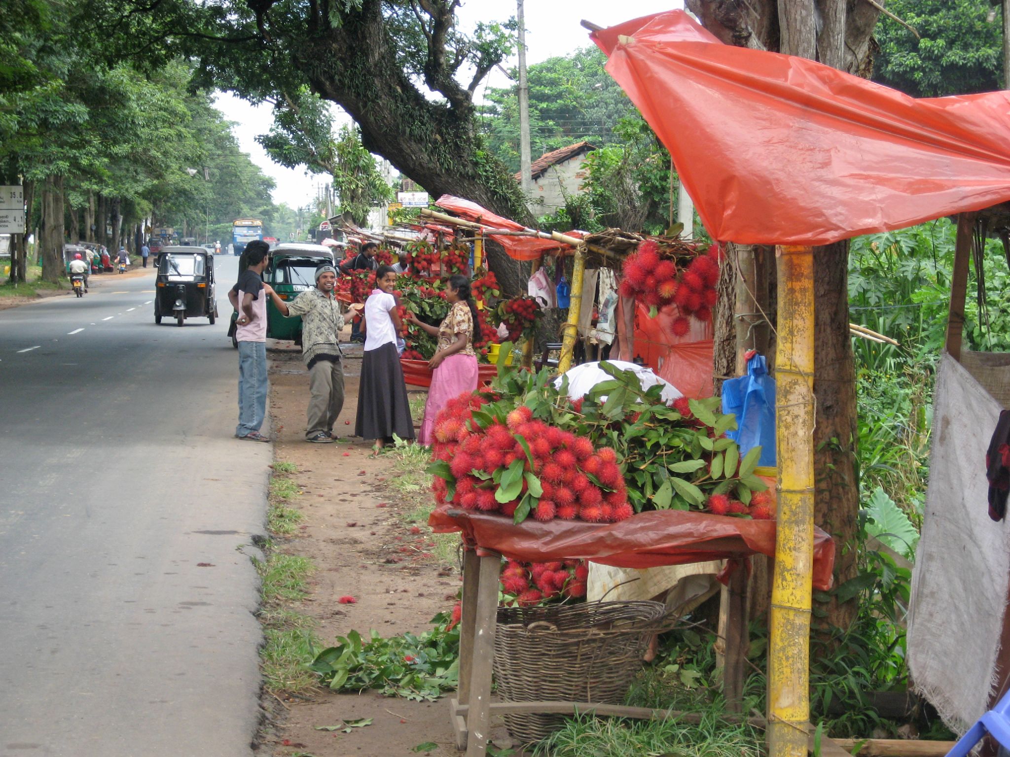 a couple of people are near some fruit