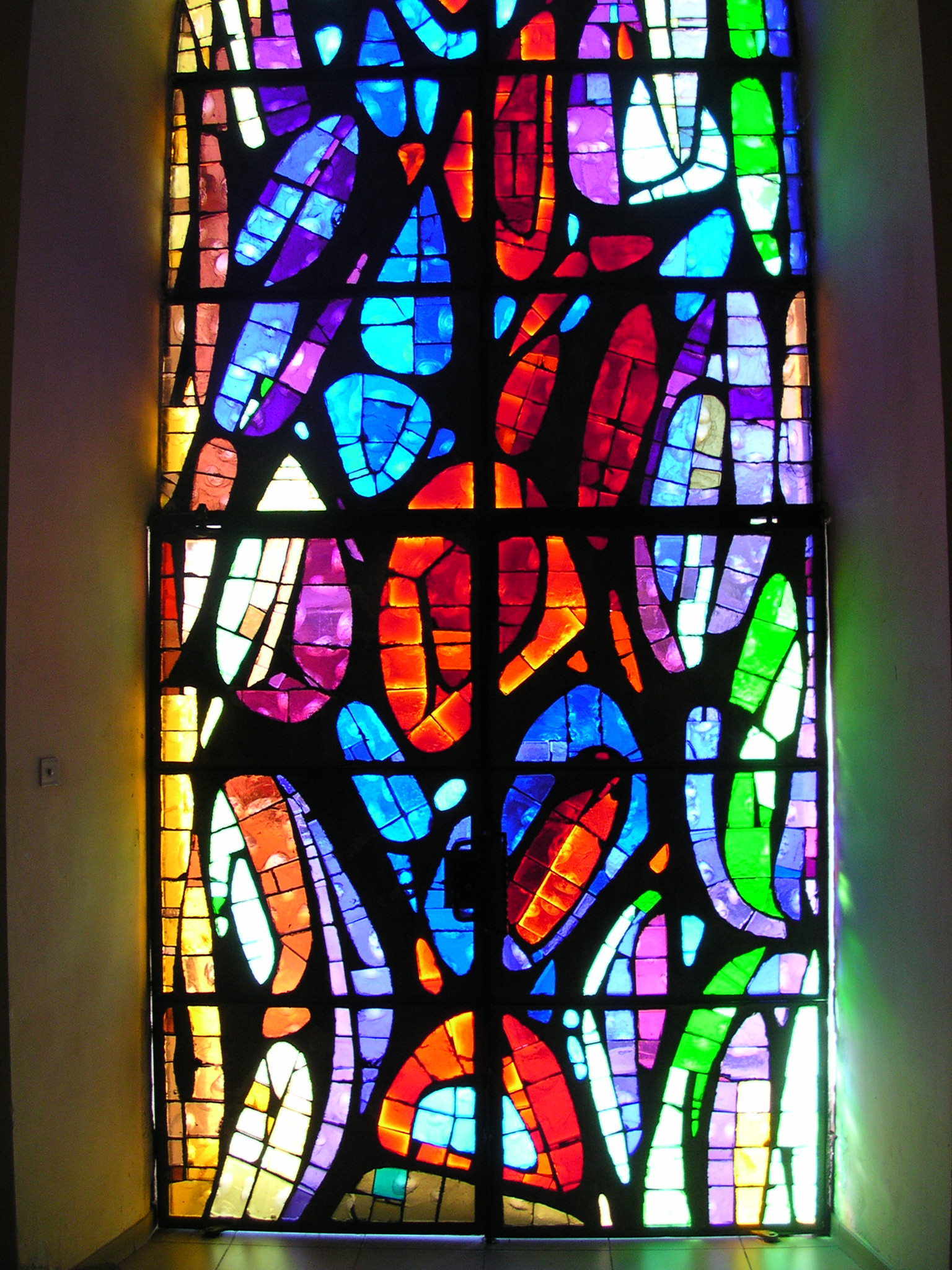 an artful stained glass window with leaves painted on it