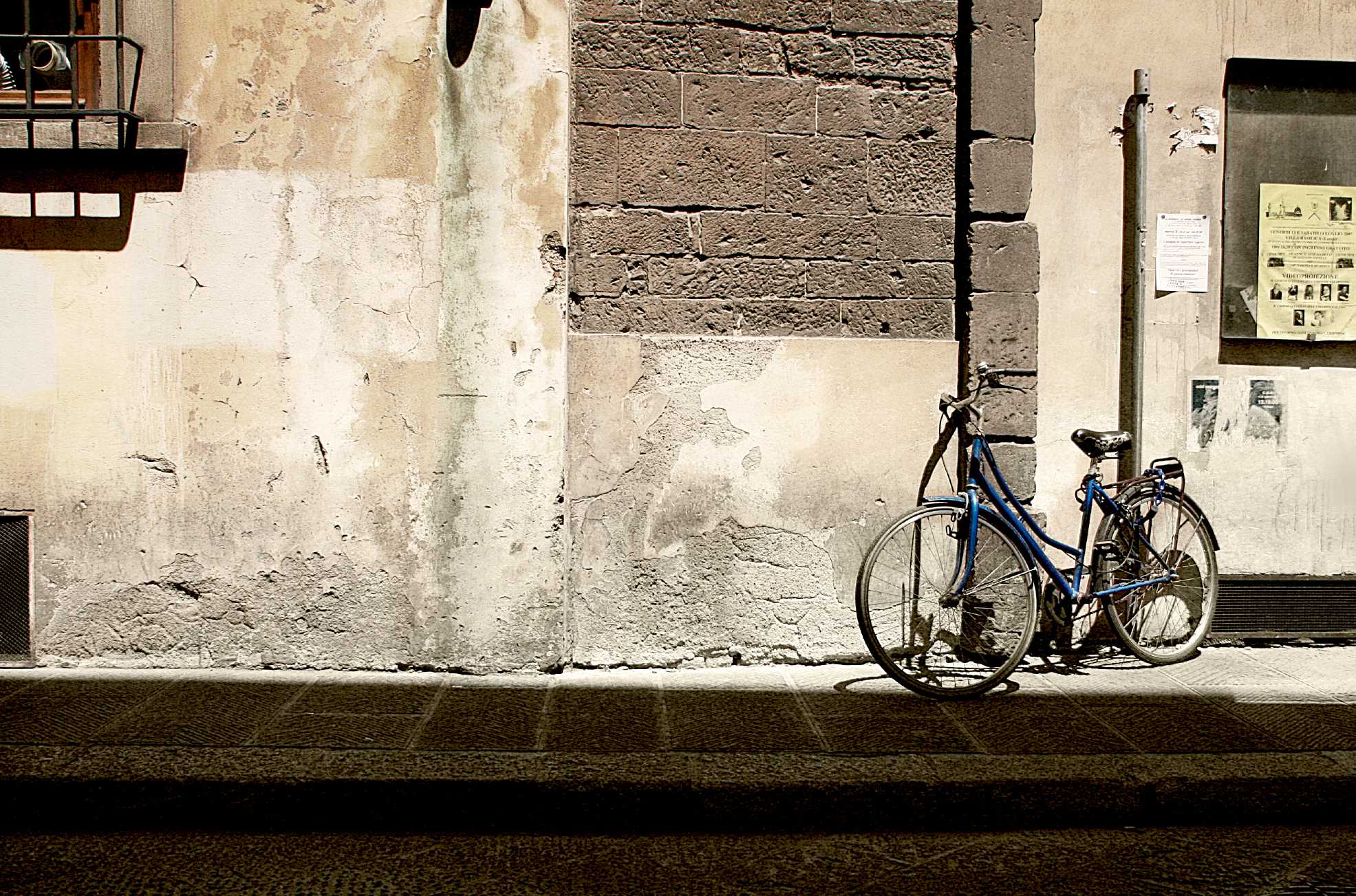 a blue bicycle parked in front of an old building