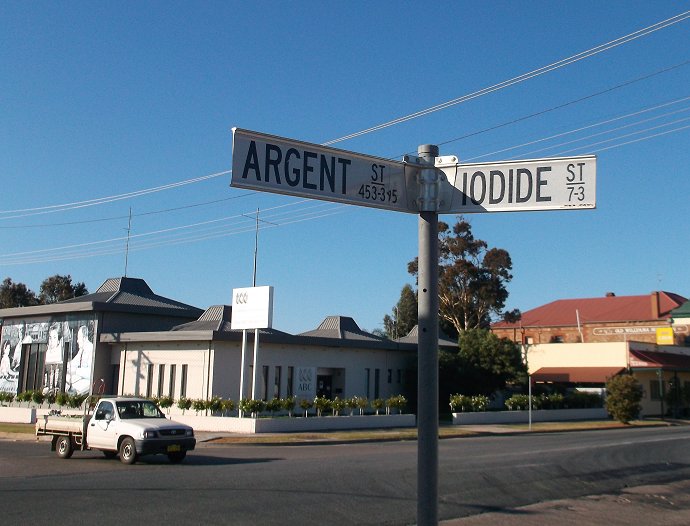 street signs in a small city setting with a blue sky