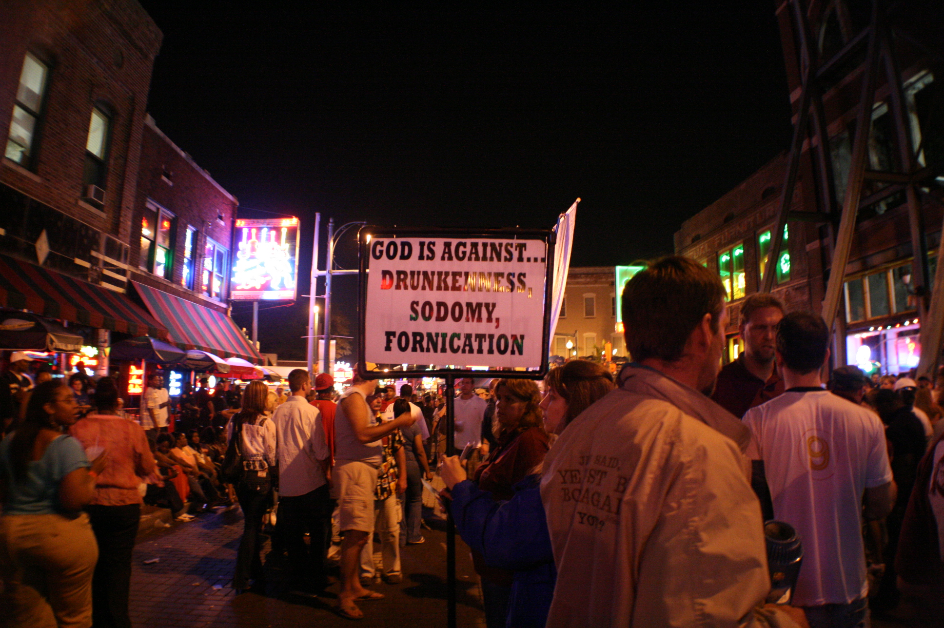 several people holding signs and lights outside at night