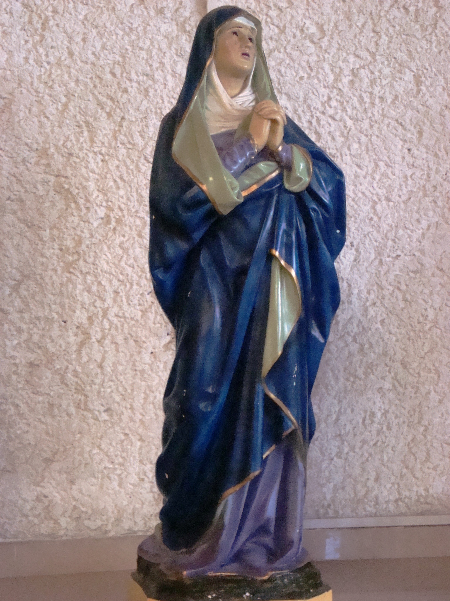 a statue with a blue dress on holding a white cloth