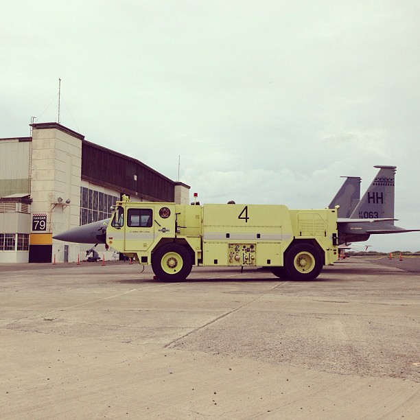 a large yellow transport truck parked in front of an airport