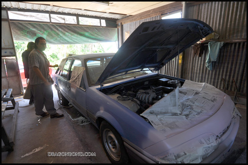 a man and his car in a garage with the hood up