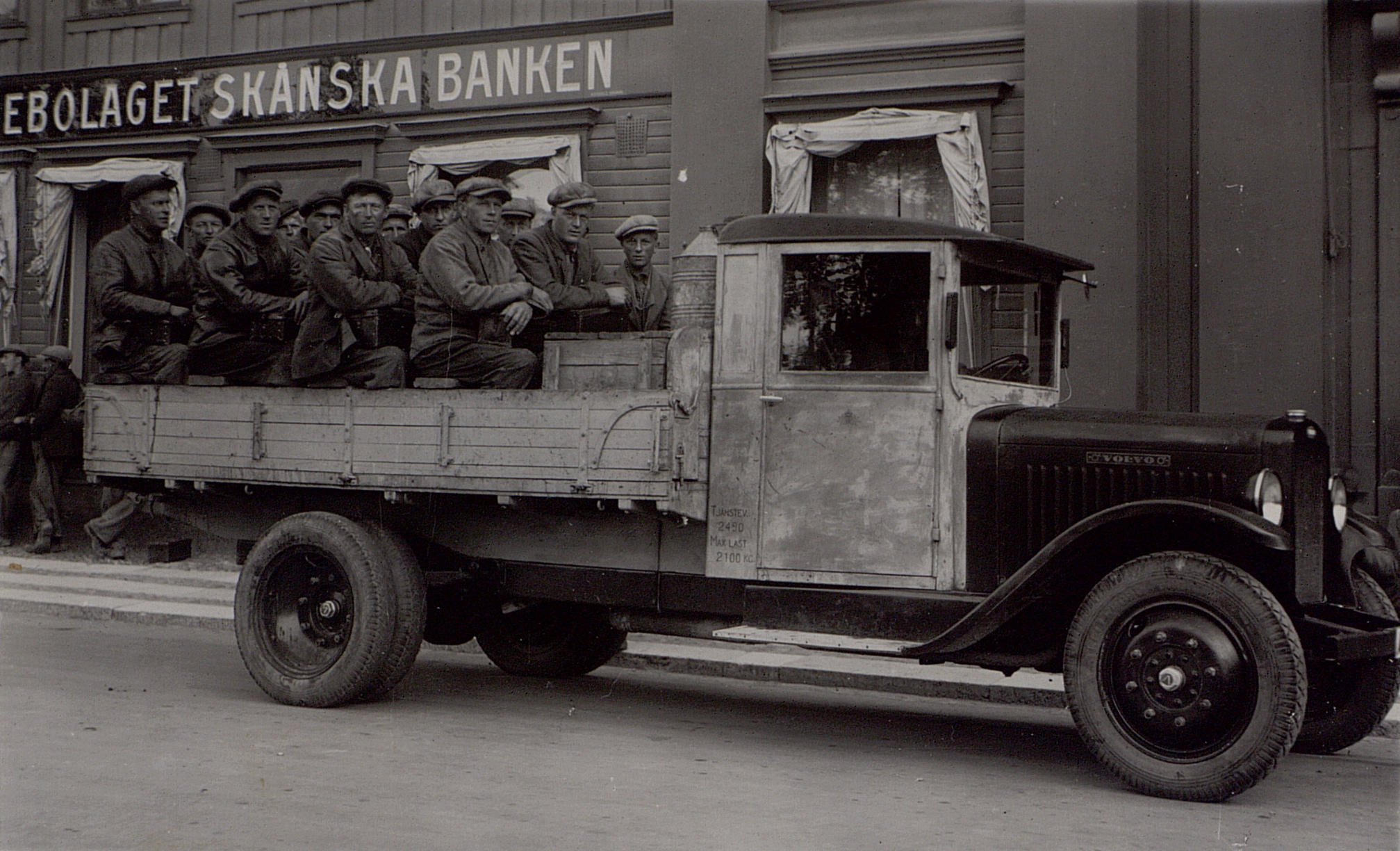 a black and white po of a group of men in the back of an old truck