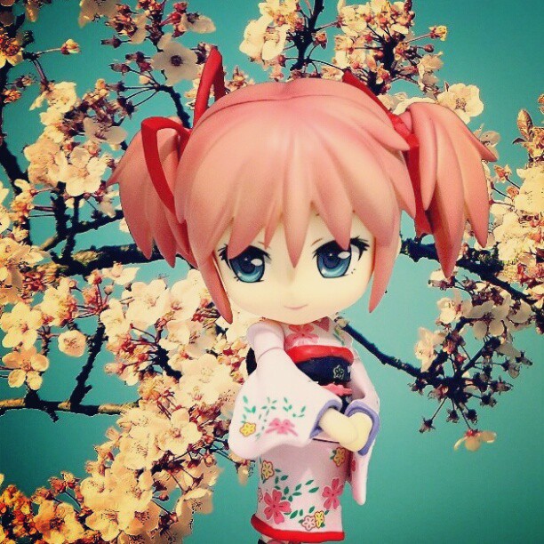 an anime doll with pink hair holding a small bag
