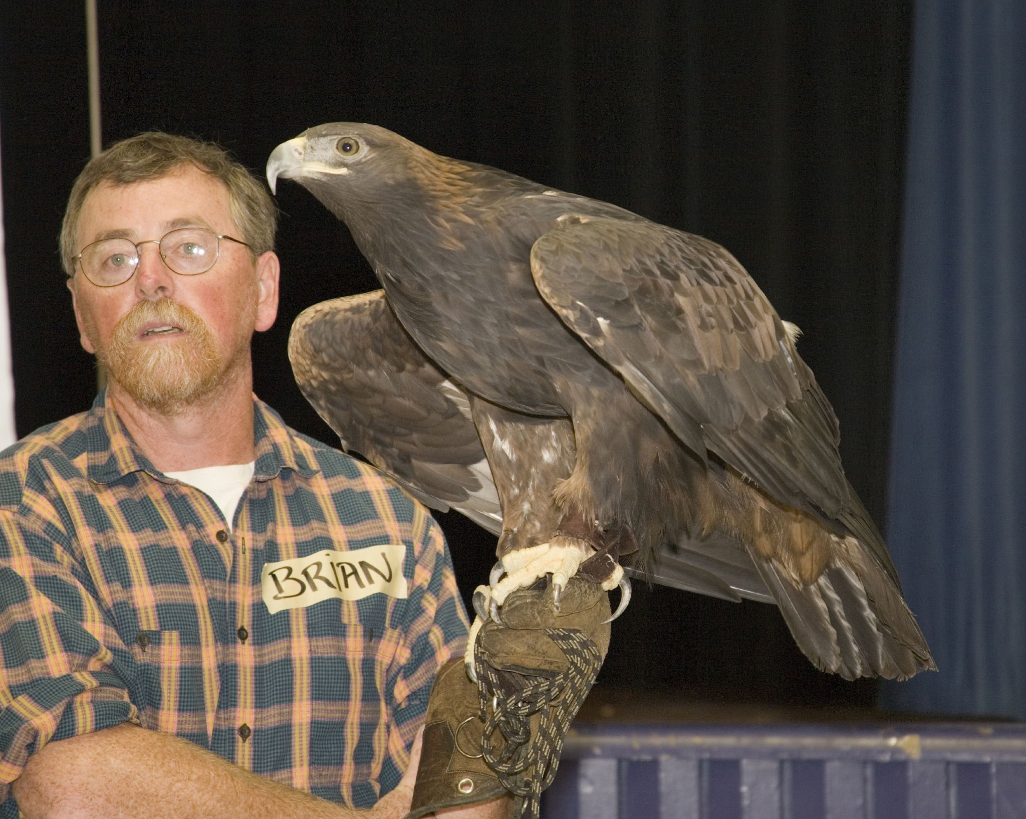 a man holds a large bird in his hands