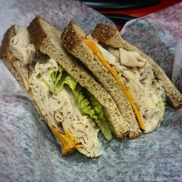 a sandwhich with chicken, lettuce and mayonnaise
