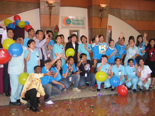 a group of people pose for a po with balloons