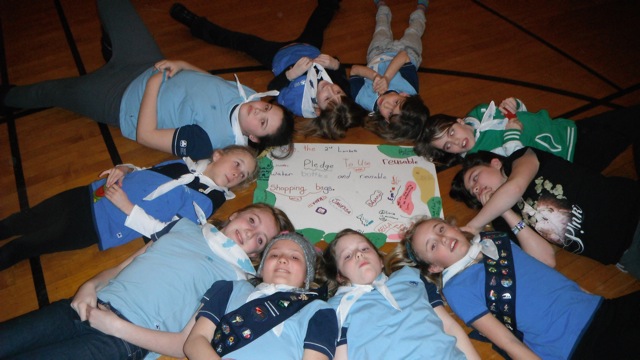 a group of s posing in a circle on the floor