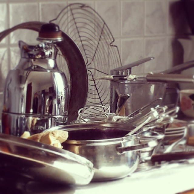 various silver pots and pans sitting on the stove