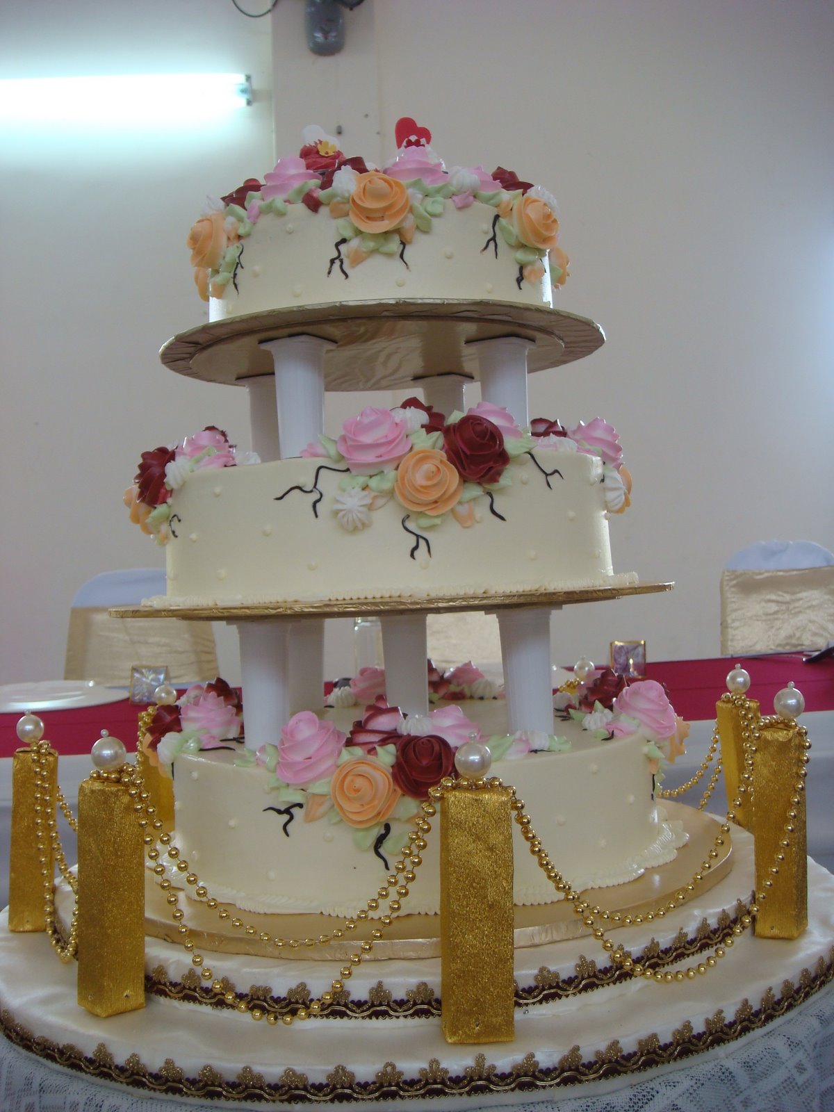 the four layer cake has a gold ribbon around it