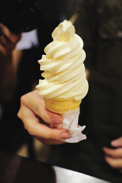 a person holding an ice cream cone with a bite taken out