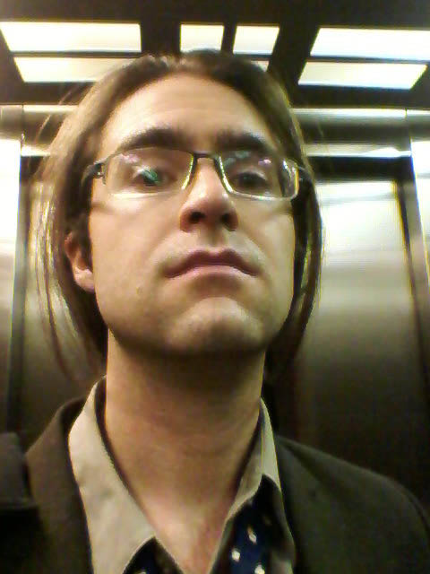 man on an elevator wearing a tie and glasses