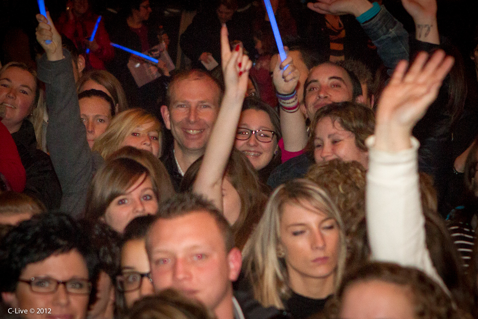 a group of people watching soing with blue lights around them