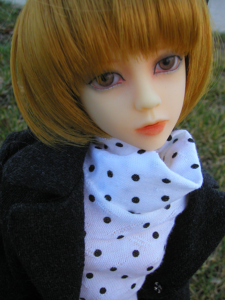 a doll with blond hair and a black jacket
