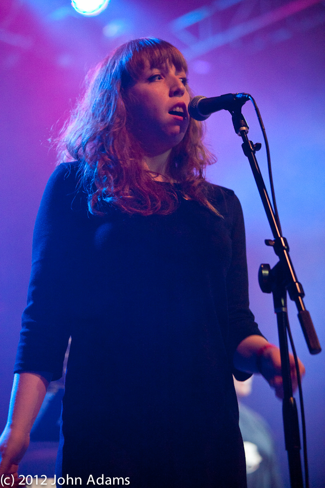 a woman holding a microphone near a speaker