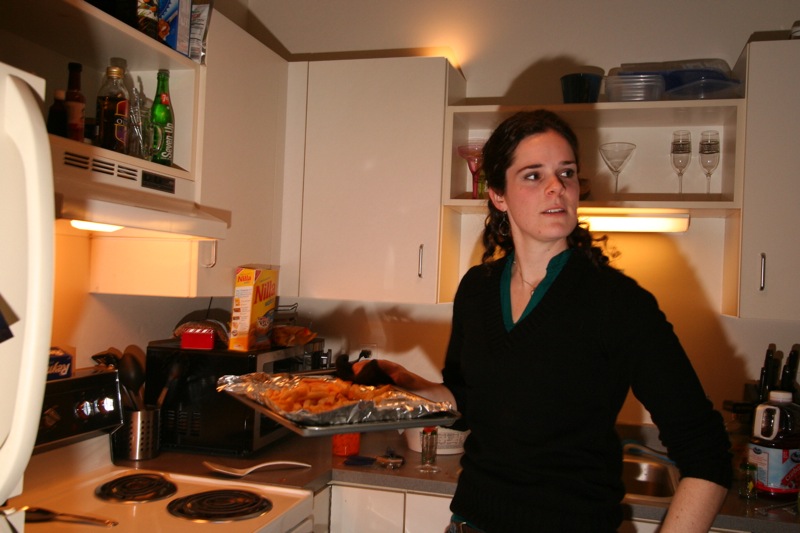 woman standing in the kitchen with a tray of food on the counter