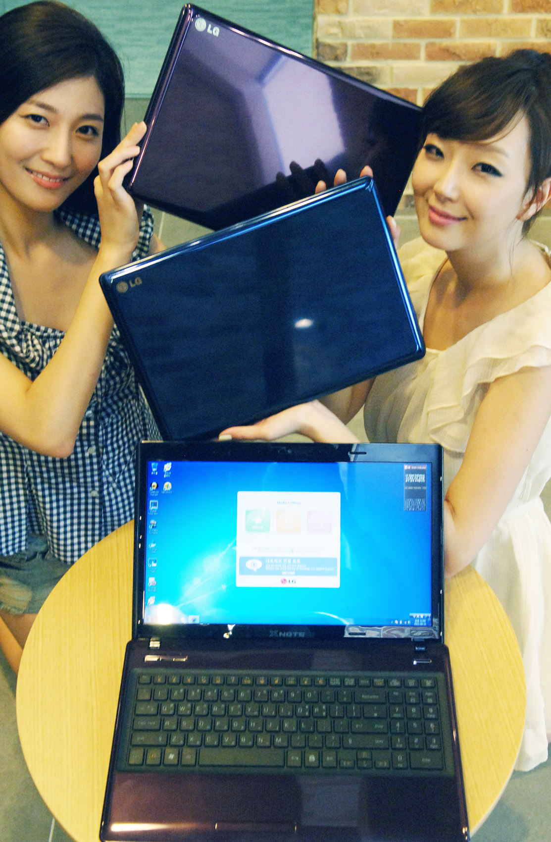 two women with open laptops are sitting at a table