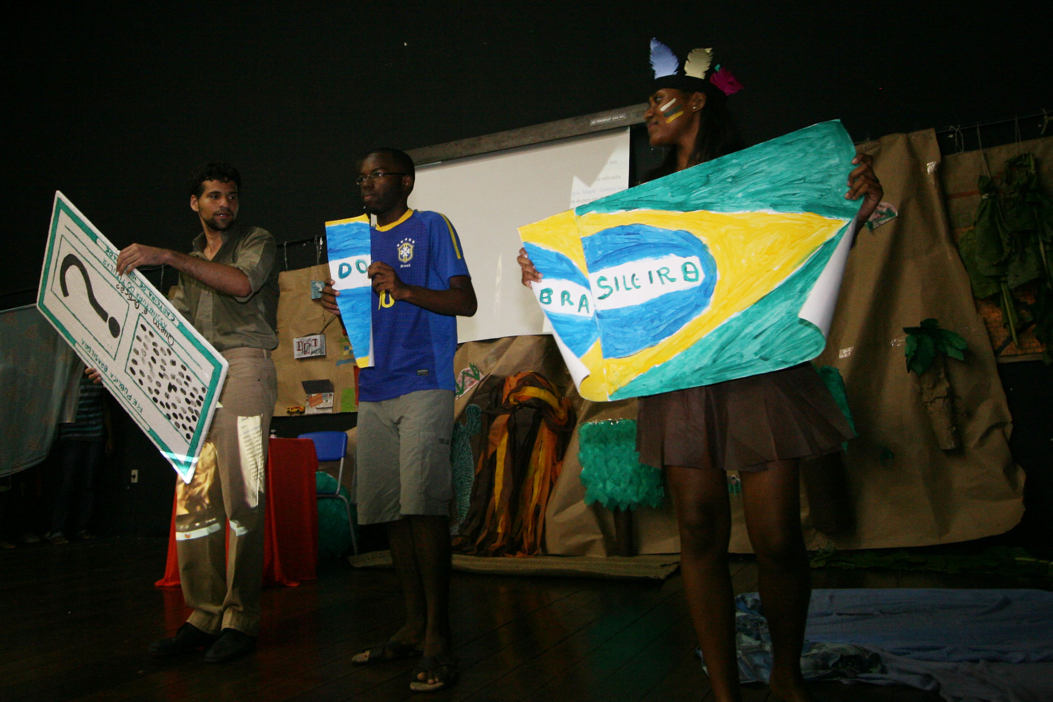 three people are posing for a picture while holding up signs