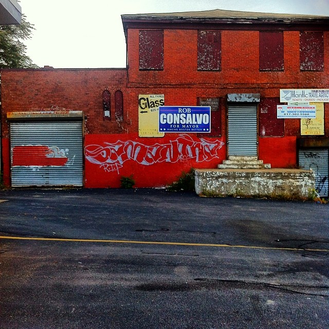 a red building with graffiti on it next to a parking lot