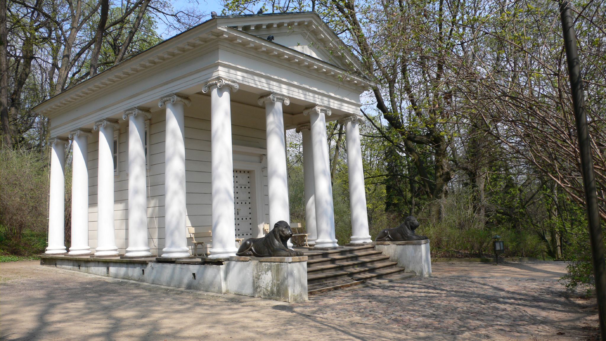 a white monument with pillars and statues on the top