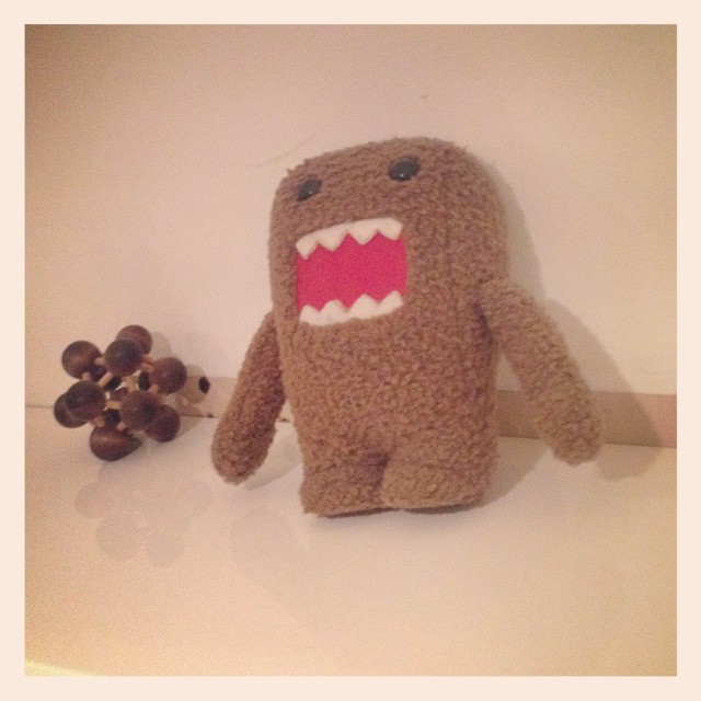 a brown monster stuffed animal next to nuts on a table