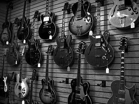 there are guitars hung on the wall for display