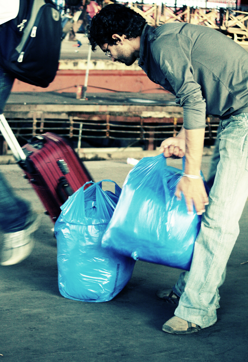 a man picking up a bag of blue bags