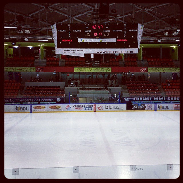 the ice rink has red seats and scoreboards