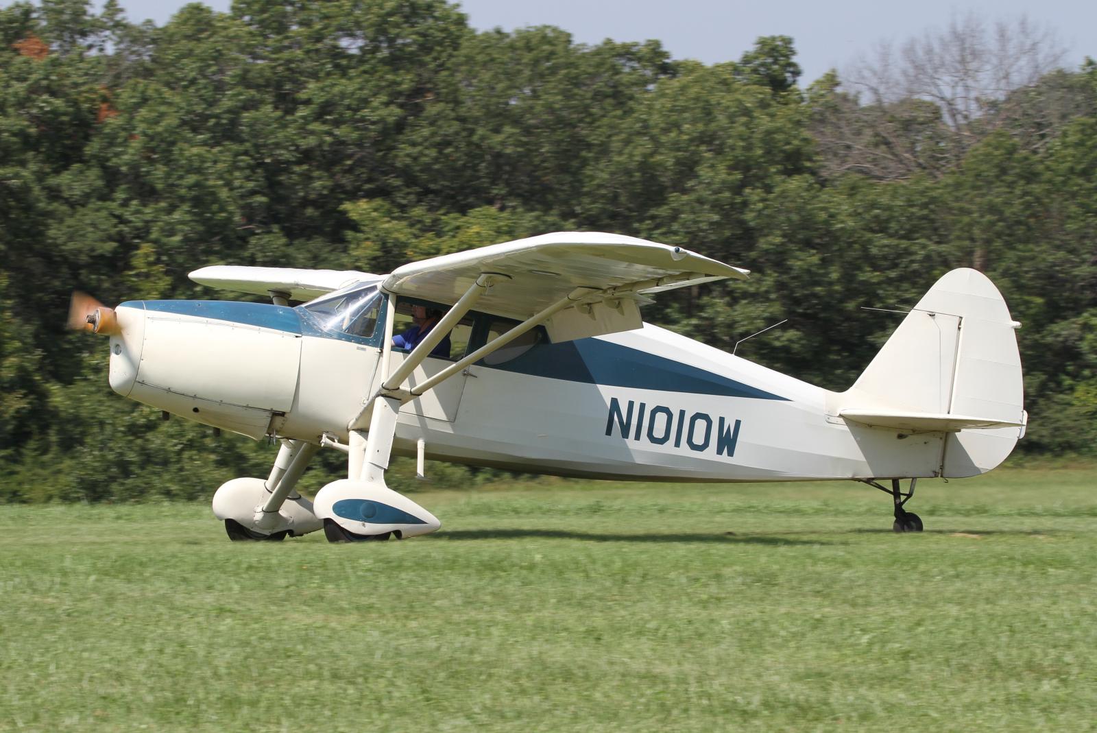 an old propeller airplane parked in a grassy field