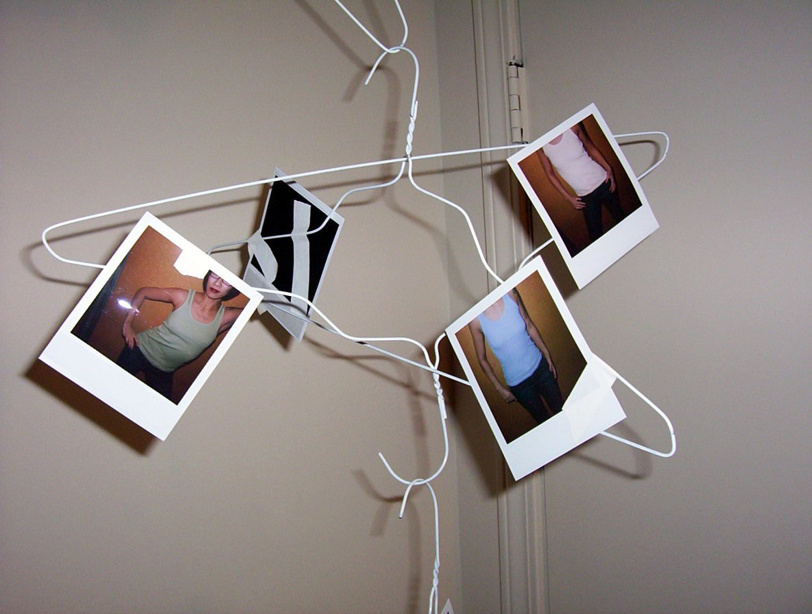 four polaroid pictures hang from a wire to display them