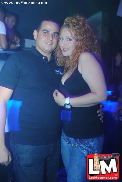 a man and woman are standing at a nightclub