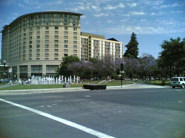 a white van driving past a fountain on the side of a road