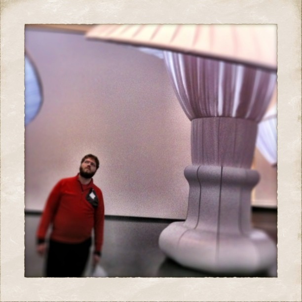 a man stands in front of a large lamp
