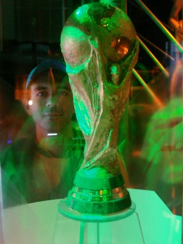 a lite - up green soccer trophy is sitting on display