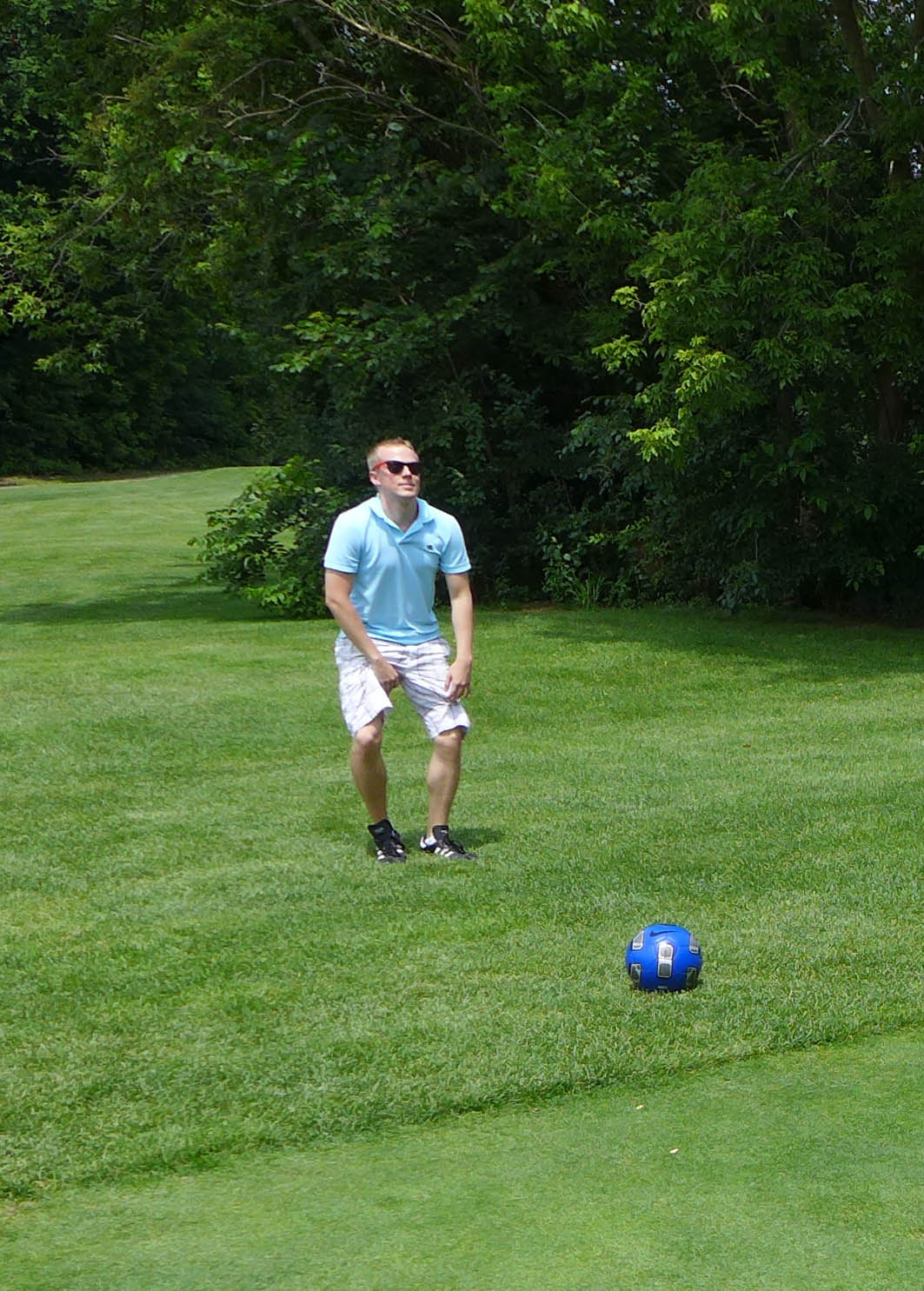 a man in blue shirt playing with soccer ball