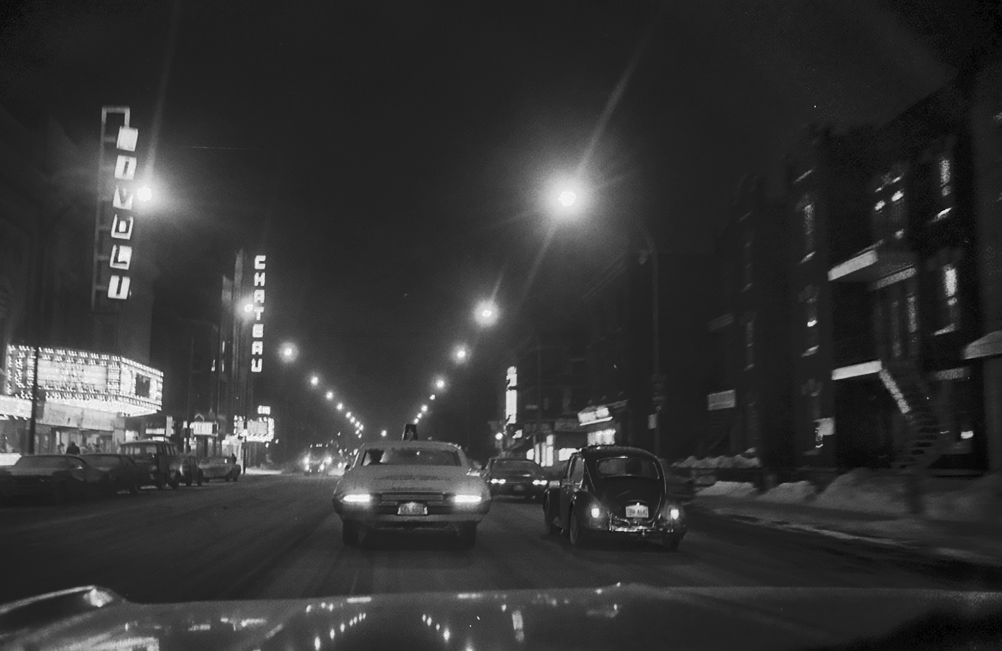 a black and white picture of cars driving on the street