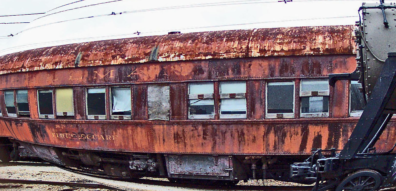 an old rusty train car on tracks next to a train