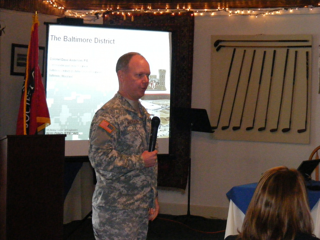 a military man giving a talk to some people