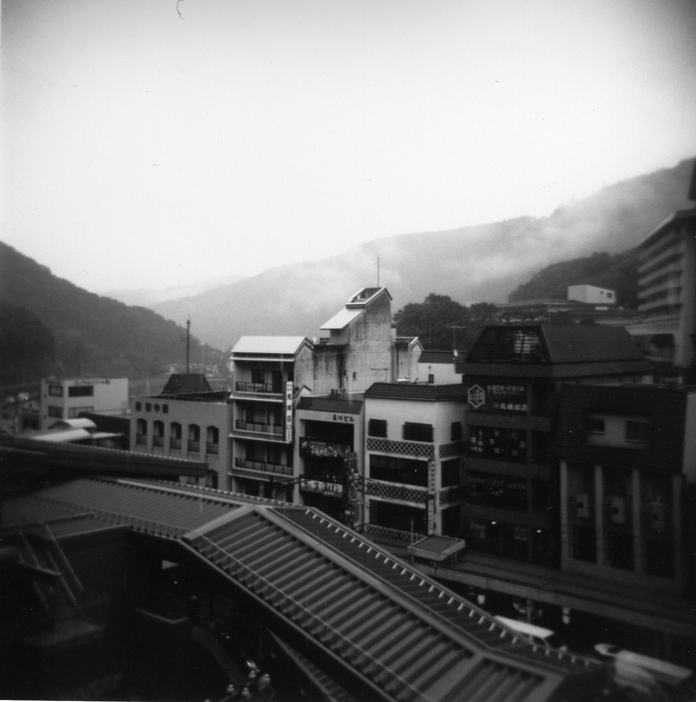 an old po of buildings with mountains in the background