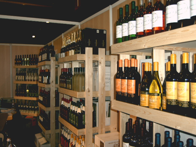 a wall of bottles and boxes sit on shelves