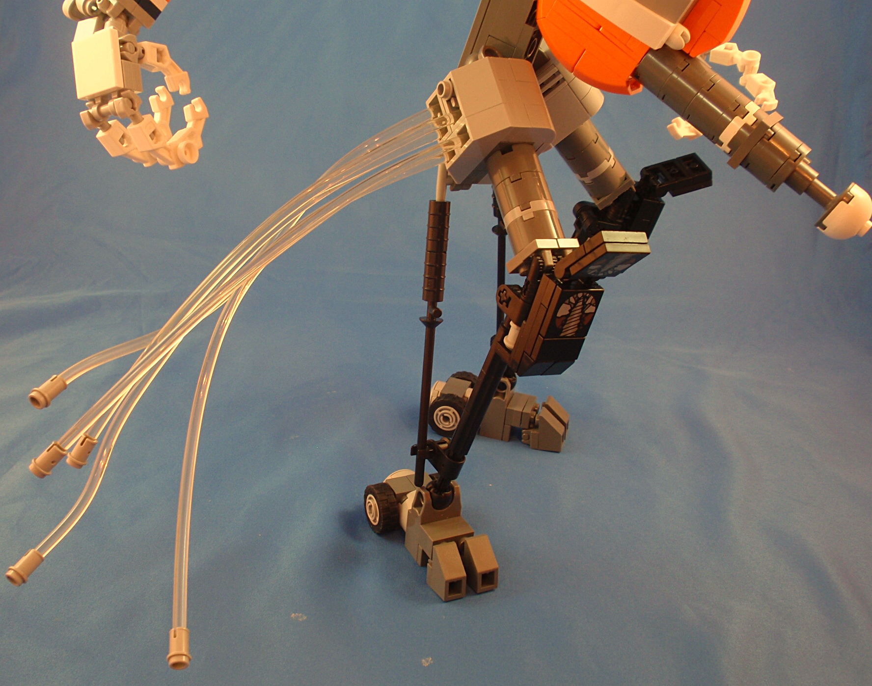 a lego robot with its arms out and legs apart