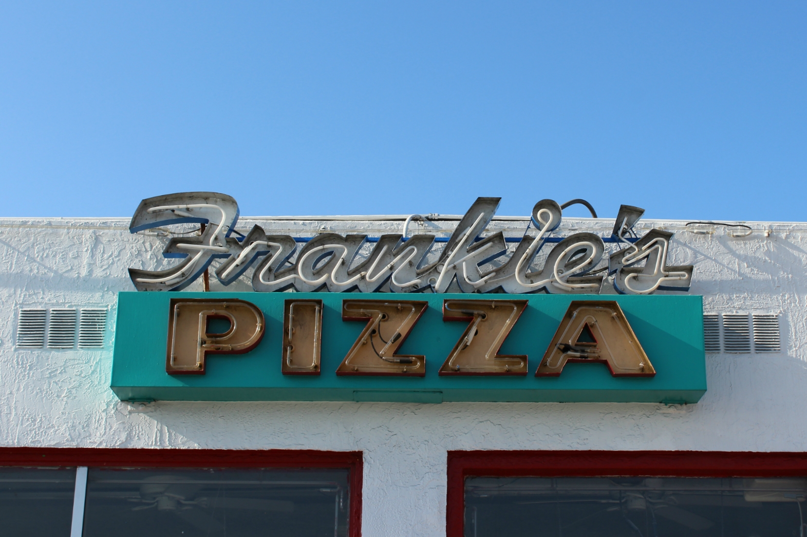 a sign that says franklins pizza above an open door