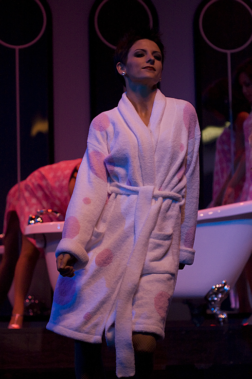 a woman with an open robe stands on the bathroom counter