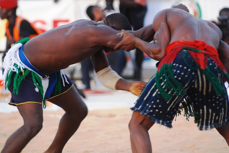 two men in native clothing are wrestling each other