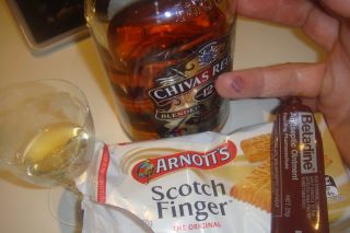 a person points at a packet of scotch finger chips with a glass