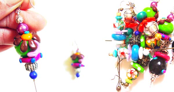 a pair of colorful earrings being held by a person