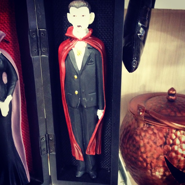 a man with a red cape standing inside of a plastic doll